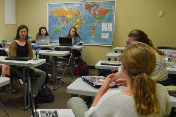 students in a classroom with a map of the world